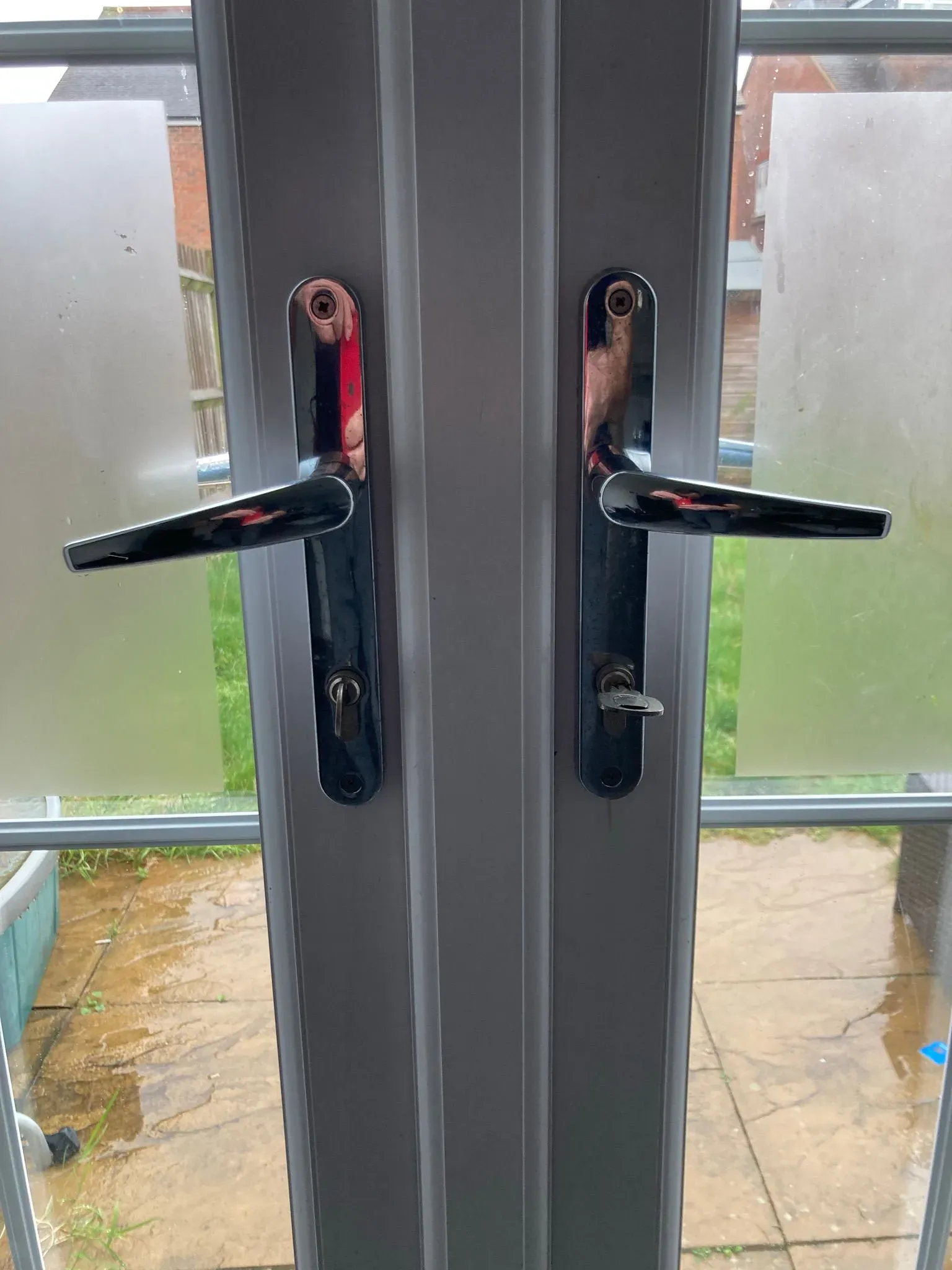 uPVC patio doors with chrome handles and keys in the locks
