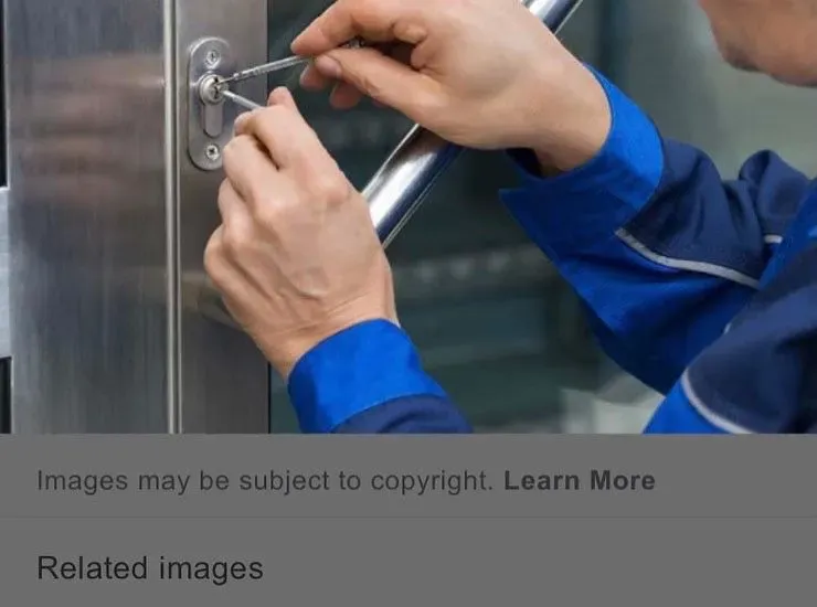 Close-up of a locksmith picking a door lock with professional tools.