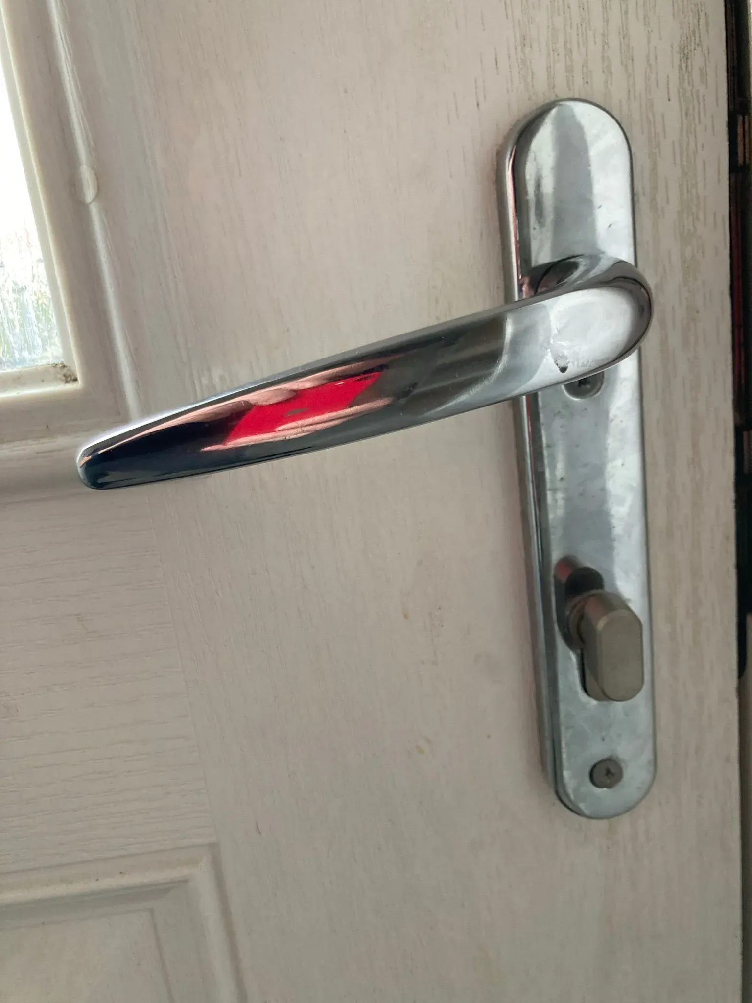 Close-up of a uPVC door handle and euro cylinder lock, showing typical components that may need repair or an upgrade.